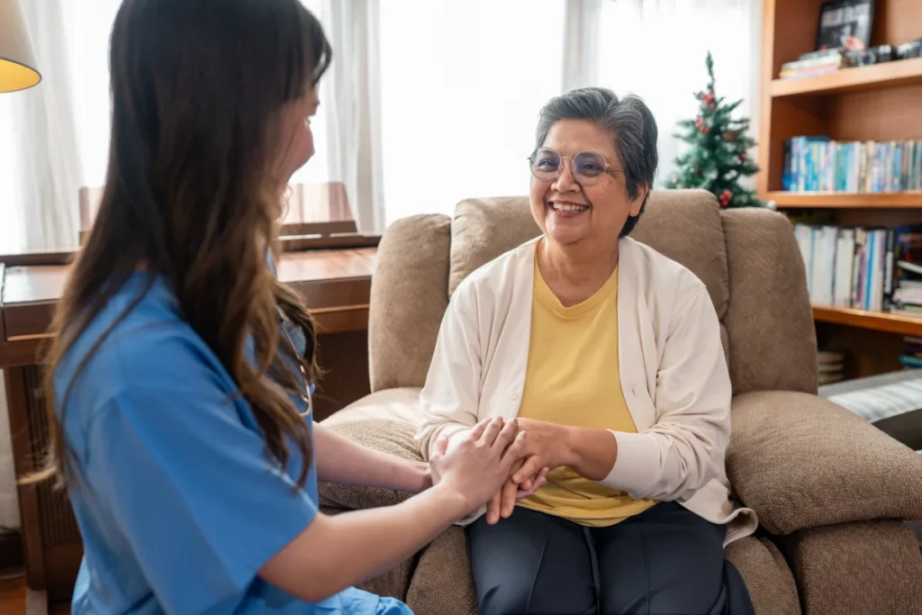 Senior woman sitting and holding hands with caretaker